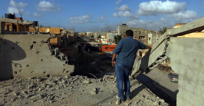Un uomo dal tetto di un edificio osserva la citt di Benghazi devastata dai combattimenti (AFP Photo)