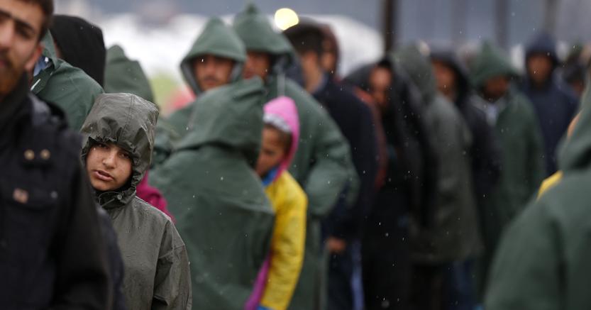 Migranti in attesa di attraversare il confine tra Grecia e Macedonia nei pressi del campo profughi di Idomeni (Reuters)