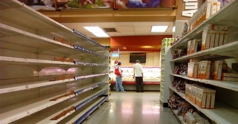 Scaffali vuoti in un supermercato di Caracas (Afp)