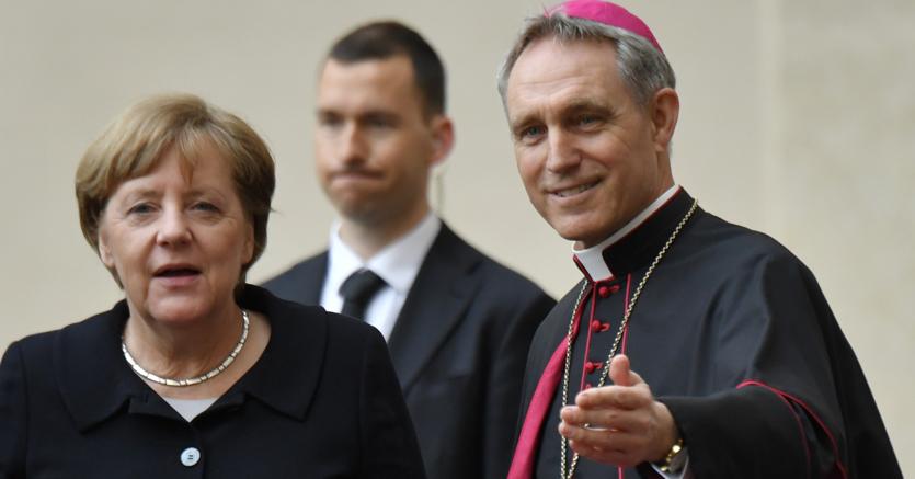 Angela Merkel accolta dal prefetto della Casa pontificia Georg Gnswein prima dell’udienza dei leader con il Papa (Afp)