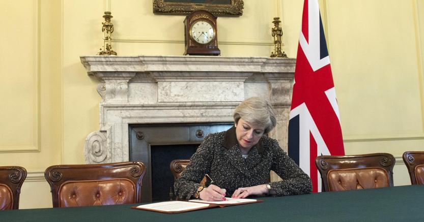 Il Premier britannico, Teresa May, firma la lettera di avvio della procedura Brexit (Epa)