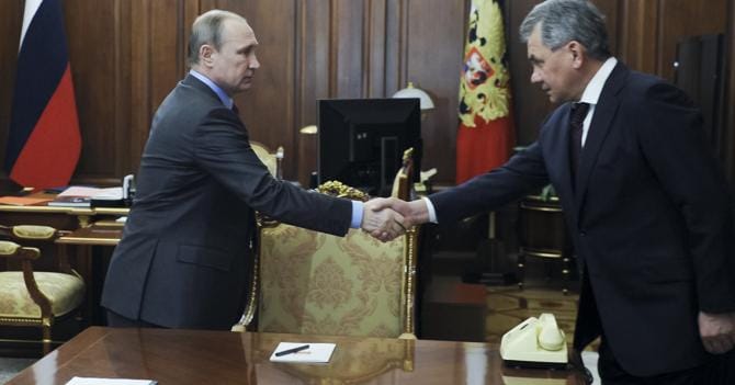 Il premier russo Vladimir Putin stringe la mano al suo ministro della difesa Sergey Shoygu per il cessate il fuoco raggiunto in Siria. (Ap)