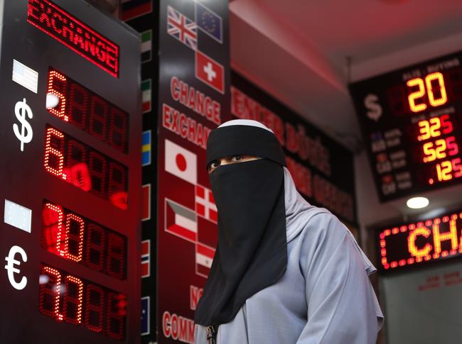 Donna turca velata in un cambia valute di Istanbul (AP)