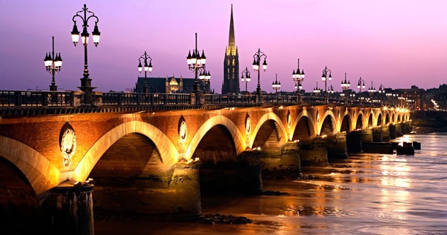 Bordeaux, il Pont de Pierre sulla Garonne al crepuscolo (foto Didier Zylberyng/Alamy/Milestone Media)