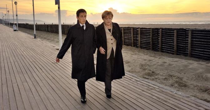 Passeggiata infausta. A Deauville i leader di Francia e Germania Nicholas Sarkozy e Angela Merkel imposero ai partner europei una ristrutturazione del debito greco a carico dei privati. (Afp) 