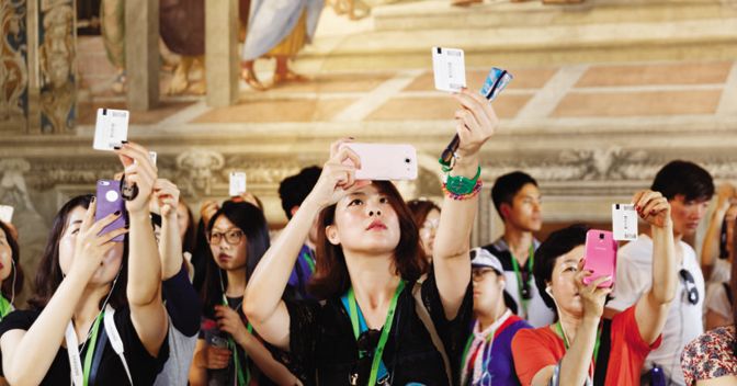  Il fotografo osserva le masse dei visitatori dei Musei Vaticani: nelle Stanze di Raffaello essi fotografano gli affreschi mettendoli a confronto con l’immagine riprodotta sul loro biglietto 