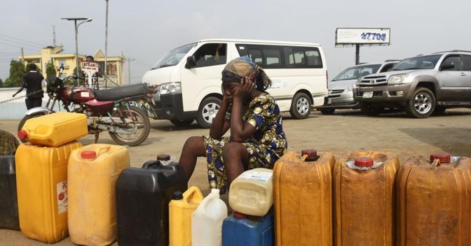 Una donna in coda per acquistare benzina a Lagos, Nigeria 