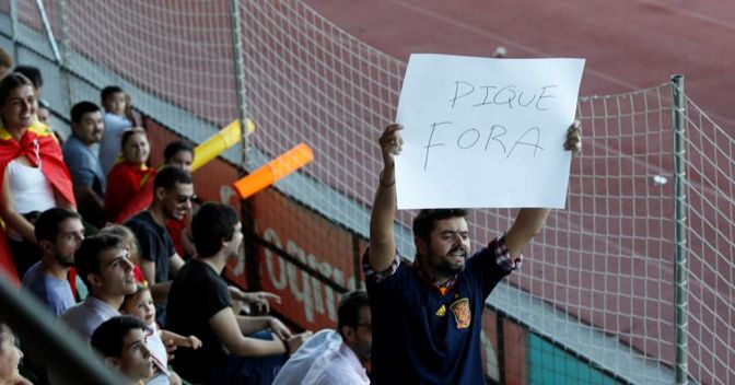 Un tifoso spagnolo espone un cartello contro il catalano Piqué prima di un allenamento (Reuters) 