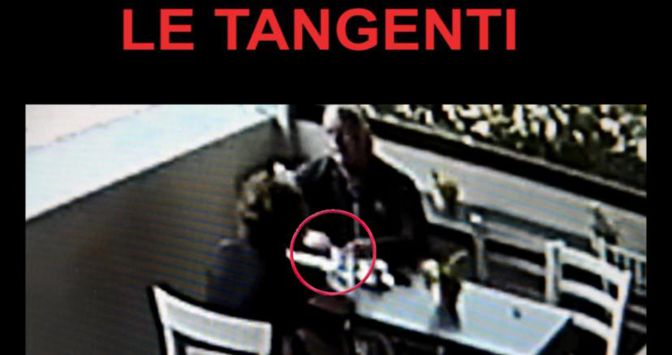 Nella foto,  il passaggio di una mazzetta in un locale pubblico 
