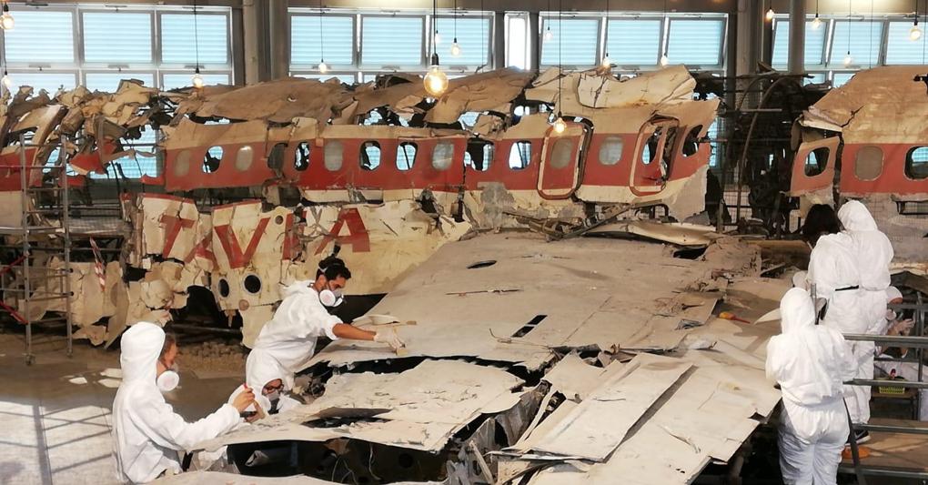 I ragazzi del corso di Restauro dell'Accademia di Belle Arti di Bologna al lavoro durante la manutenzione del relitto del Dc9 di Ustica, ospitato nel Museo per la Memoria del massacro di Bologna (Ansa) 