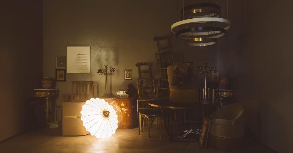 Una vista dell'Installazione Oublié di DIMOREMILANO, alla Milano Design Week 2022. Da sinistra, illuminata, lampada Oriente A, in seta stampata disponibile in 3 varianti; in alto a destra lampadario Lumière, in ottone ossidato e anelli in ottone verniciato con diffusore in opal perspex; sul tavolo e in primo piano, poltroncina Sciura in tessuto con frange decorative. Tutto DIMORESTUDIO. ©Lea Anouchinsky 
