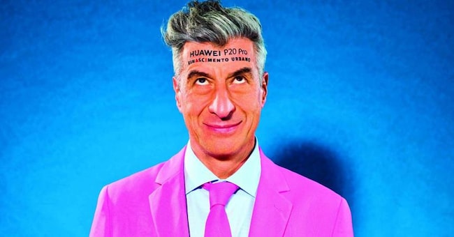 L’artista Maurizio Cattelan con un tatuaggio che promuove Huawei P20 Pro: orizzonti di marketing non convenzionale 