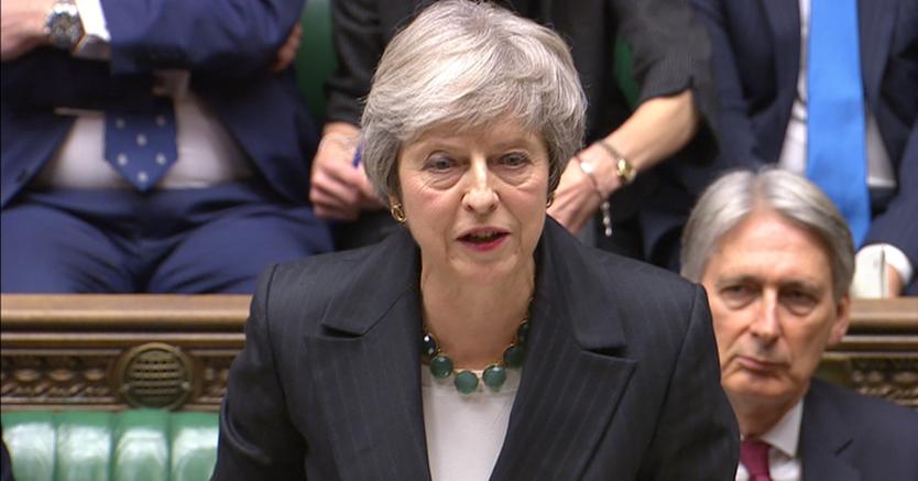 Theresa May durante il discorso a Westminster, sullo sfondo il ministro del Tesoro Philp Hammond  (Reuters)