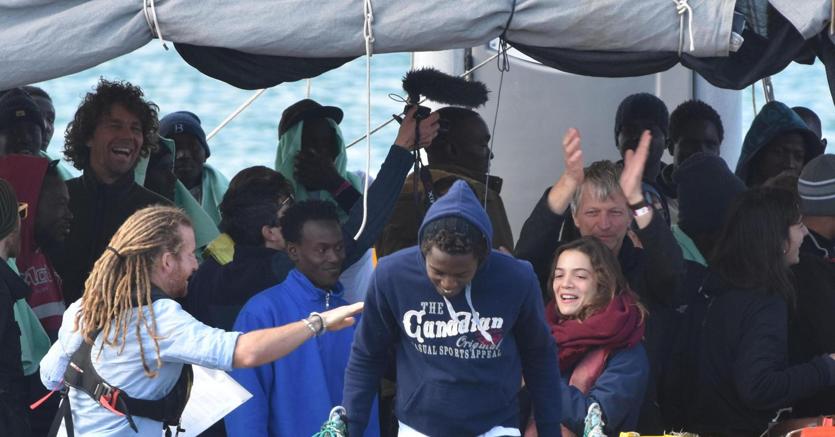 I migranti accolti dai soccorritori e volontari cominciano a sbarcare dalla Sea Watch nel molo di Levante del porto di Catania. È il 31 gennaio (foto Ansa)