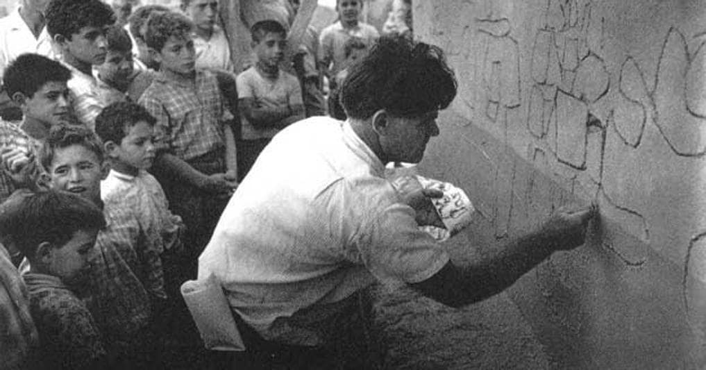 Nivola nel 1959, mentre in mezzo ai suoi concittadini lavora alla facciata della chiesa della Madonna de sa Itria di Orani 