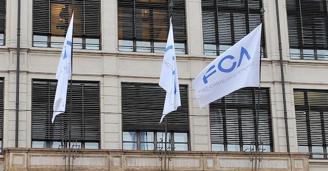 Bandiere con la sigla FCA esposte sulla facciata della palazzina del Lingotto a Torino (Ansa)