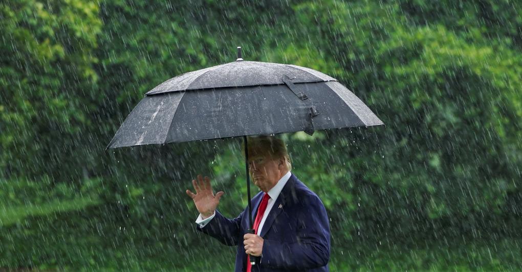 Donald Trump sotto la pioggia nel giardino della Casa Bianca prima di partire per Dallas (Reuters) 