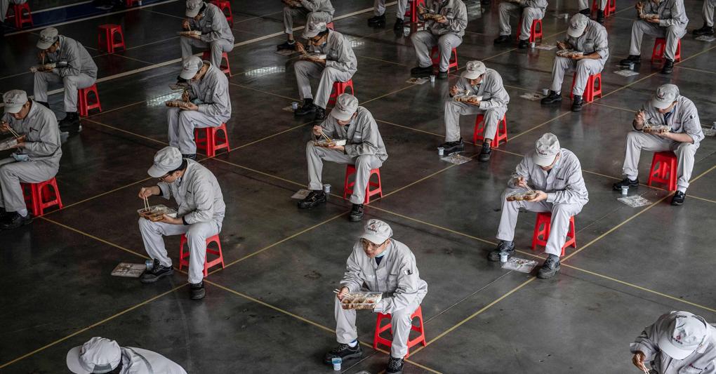 Impiegati in pausa pranzo, distanziati, nella fabbrica Honda di Wuhan il 23 marzo 2020. Foto dell’anno Afp 