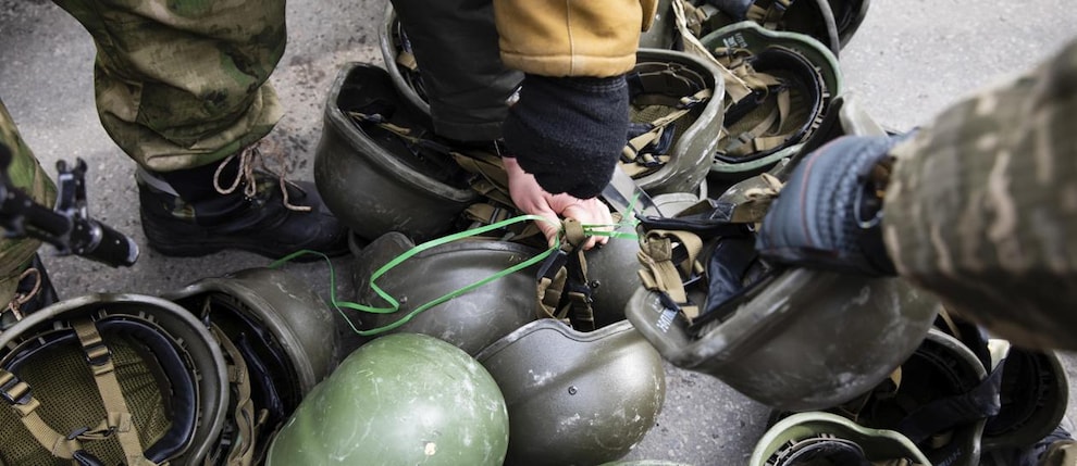 I membri dell’unità di difesa territoriale scelgono gli elmetti a uno dei posti di blocco a Kiev, Ucraina, 04 marzo 2022 - Epa