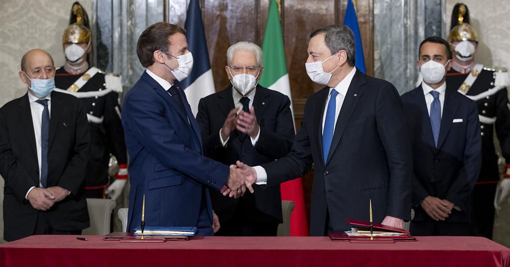  Macron e Draghi si stringono la mano dopo la firma del trattato, sotto gli occhi di Mattarella 