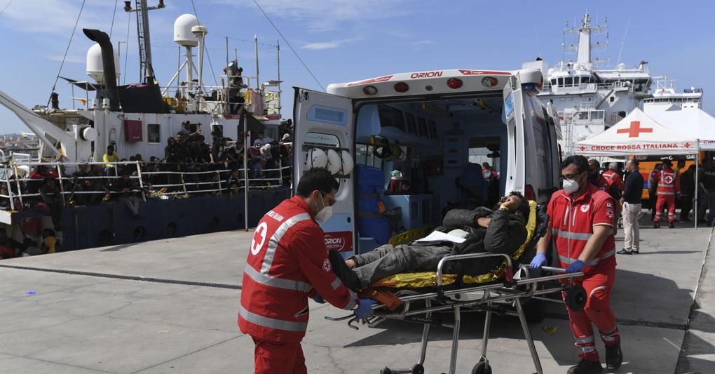 Paramedici impegnati in operazioni di accoglienza migranti nel porto di Catania il 12 aprile 2023 (foto Ap/Cavalli) 