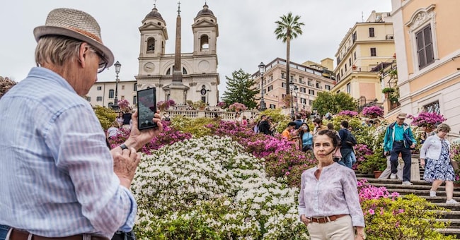Turisti a Piazza di Spagna con la scala di Trinità dei Monti addobbata con fiori (Agf)