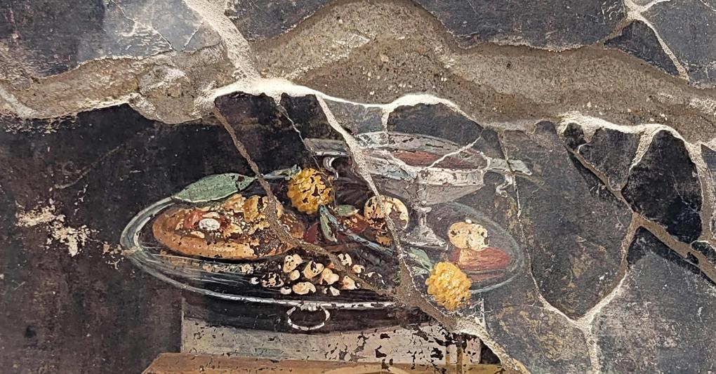 L’affresco con una pietanza che ricorda la pizza scoperto a Pompei (AFP) 