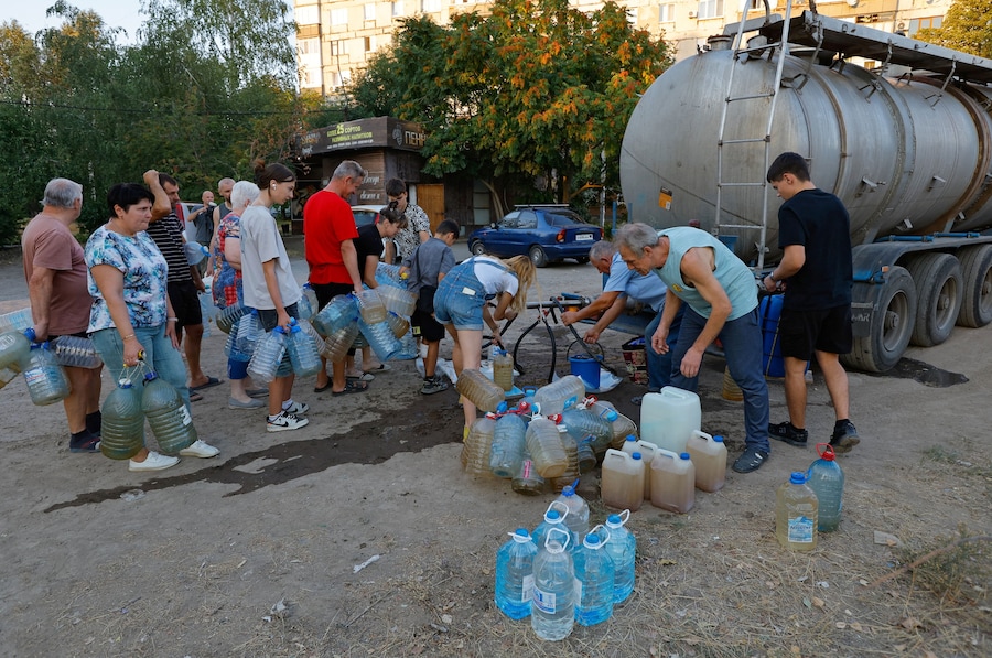 Residenti aspettano in fila per raccogliere l'acqua consegnata da un camion cisterna nel corso del conflitto militare tra Russia e Ucraina, a Donetsk, città dell'Ucraina controllata dai russi. (REUTERS/Alexander Ermochenko)