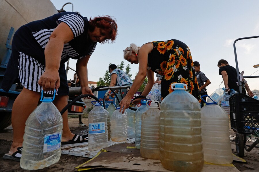 Un gruppo di persone raccoglie l'acqua consegnata da un camion cisterna nel corso del conflitto militare tra Russia e Ucraina, a Donetsk, città ucraina controllata dai russi. (REUTERS/Alexander Ermochenko)