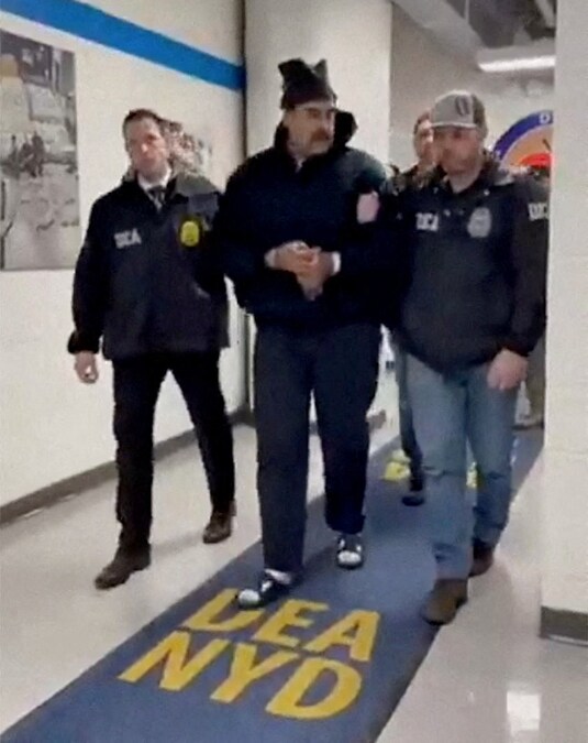 Un’immagine tratta dal video pubblicato dall’account Rapid Response 47 della Casa Bianca su X.com mostra il presidente venezuelano Nicolas Maduro mentre viene portato in custodia lungo un corridoio presso gli uffici della Drug Enforcement Administration (DEA) degli Stati Uniti a New York City, (via REUTERS)