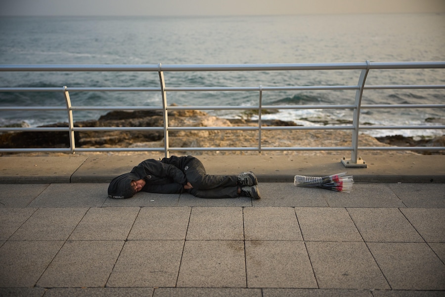 Un ragazzo dorme all'aperto accanto alle rose che vende ai passanti per guadagnarsi da vivere, lungo una passeggiata sul lungomare nel centro di Beirut, in Libano, domenica 5 aprile 2026. (AP Photo/Emilio Morenatti) (APN)