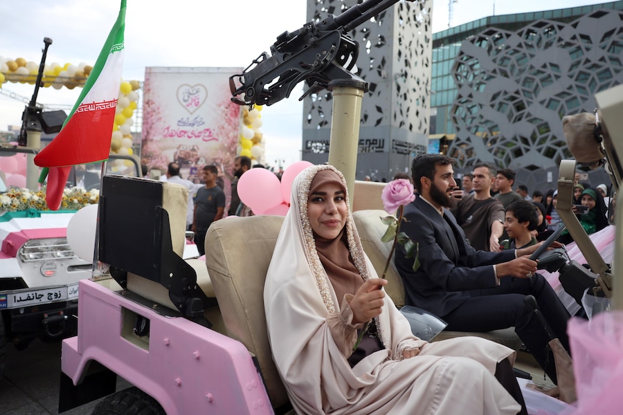 epa12971876 Una coppia di sposi iraniani arriva a bordo di un veicolo militare durante una cerimonia di nozze di massa organizzata nell'ambito della campagna "Jan-Fada" (Sacrificio della vita) a Teheran. Il conflitto tra Iran e Stati Uniti continua, mentre il presidente americano Donald Trump ha ribadito le minacce di nuove azioni militari contro l'Iran. (Epa)