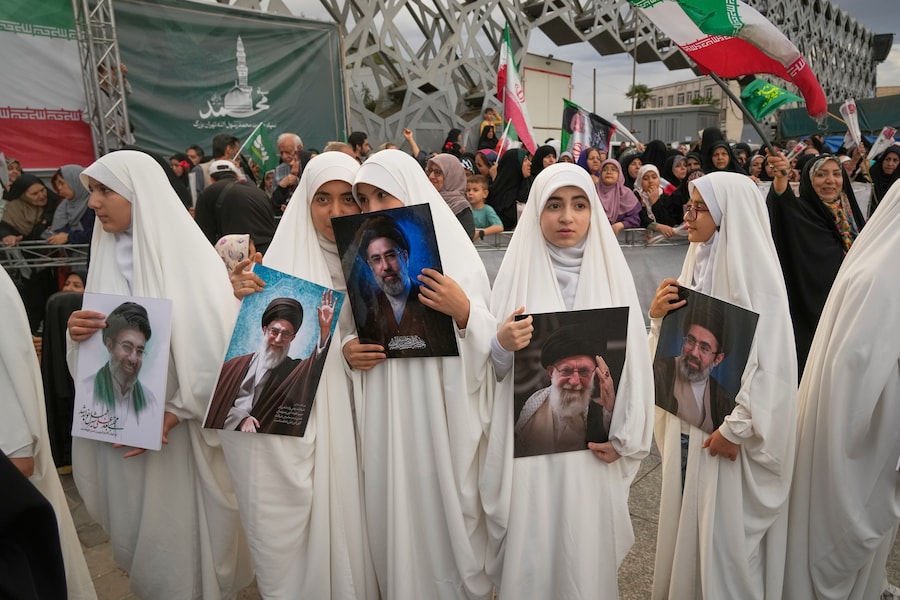 Un gruppo di ragazze tiene in mano i ritratti della Guida Suprema dell'Iran, l'Ayatollah Mojtaba Khamenei, e del suo defunto padre, l'ex Guida Suprema Ayatollah Ali Khamenei, durante una cerimonia di matrimonio di massa per le coppie che partecipano alla campagna filogovernativa "Janfada" (Apn)