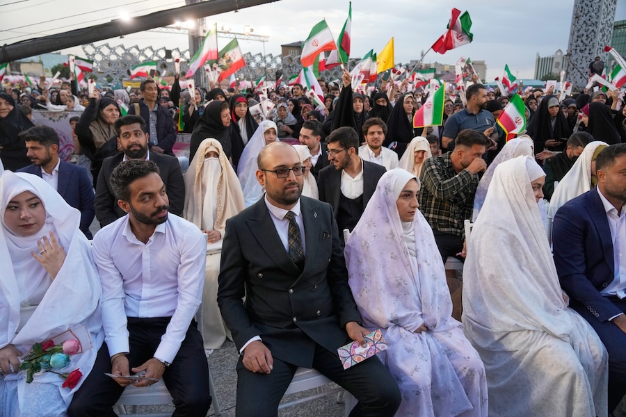 Coppie sedute durante una cerimonia di matrimonio collettiva per i partecipanti alla campagna filogovernativa "Janfada" ("Sacrificio per l'Iran") a Teheran (Apn)