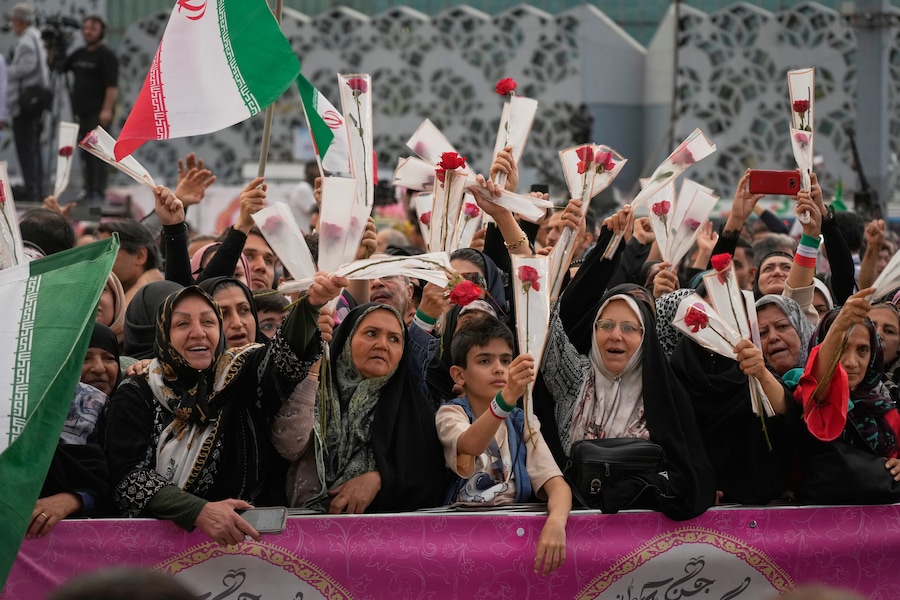 Le persone tengono in mano delle rose mentre partecipano a una cerimonia di matrimonio collettivo per le coppie che aderiscono alla campagna governativa "Janfada" ("Sacrificio per l'Iran") a Teheran. (Apn)