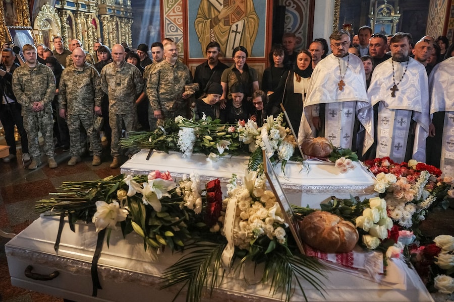 Parenti e amici partecipano alla cerimonia funebre delle sorelle Yakovlieva, Vira, 17 anni, e Liubava, 12 anni, rimaste uccise in un attacco missilistico (Reuters)