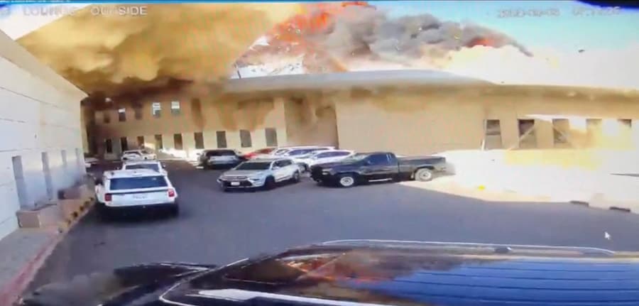 Un filmato delle telecamere a circuito chiuso mostra un'auto che lascia un parcheggio mentre fiamme e fumo si levano in seguito a un attacco all'Aeroporto Internazionale del Kuwait a Kuwait City, in Kuwait, il 3 giugno 2026, in questo screenshot tratto da un video. Civil Aviation Kuwait/Handout via REUTERS (via REUTERS)