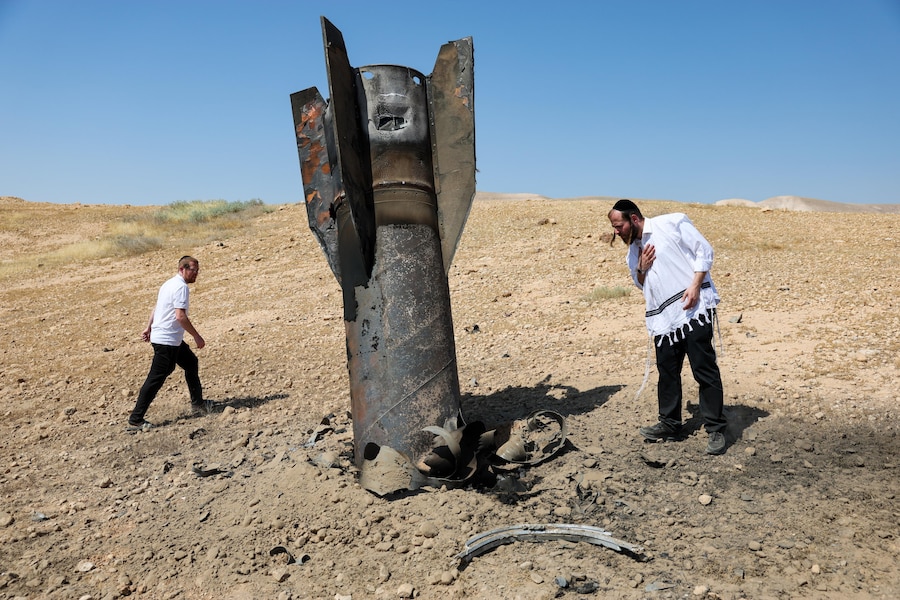 Ebrei ultraortodossi osservano i resti di un missile balistico iraniano caduto in un campo aperto vicino all'insediamento di Mevo'ot Yericho, in Cisgiordania, nella Valle del Giordano. L'Iran ha lanciato missili contro Israele in rappresaglia a un precedente attacco israeliano contro la periferia sud di Beirut. (Epa)
