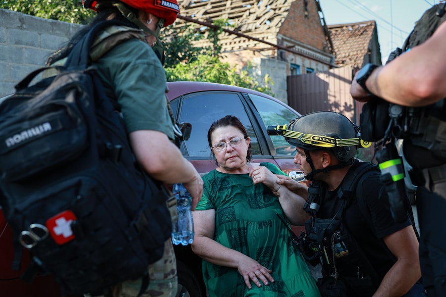 Alcuni agenti di polizia soccorrono una donna dopo un attacco contro un quartiere residenziale di Zaporizhzhia, in Ucraina. (Foto AP/Kateryna Klochko) (Apn)