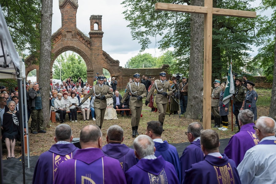 Alcune persone partecipano a una cerimonia commemorativa in memoria delle vittime del massacro di Volinia presso il cimitero cattolico romano di Olyka (EPA)