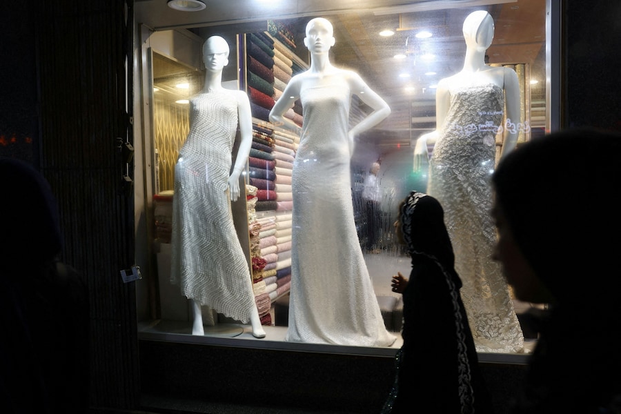 People walk in front of a store window in Bandar Abbas, Iran, August 25, 2026. Majid Asgaripour/WANA (West Asia News Agency) via REUTERS ATTENTION EDITORS - THIS IMAGE HAS BEEN SUPPLIED BY A THIRD PARTY. ISRAEL OUT. NO COMMERCIAL OR EDITORIAL SALES IN ISRAEL. NO ACCESS FOR ISRAELI MEDIA. NO USE BBC PERSIAN. NO USE VOA PERSIAN. NO USE MANOTO. NO USE IRAN INTERNATIONAL. NO USE RADIO FARDA. DIGITAL: NO USE BBC PERSIAN. NO USE VOA PERSIAN. NO USE MANOTO. NO USE IRAN INTERNATIONAL. NO USE RADIO FARDA. (via REUTERS)