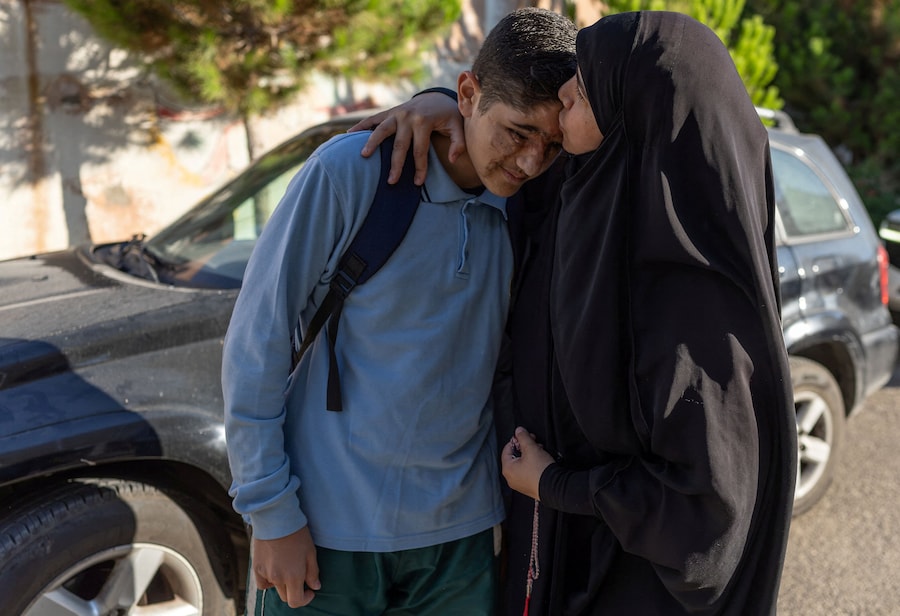 Sarah Zreik bacia suo figlio, Ali Abbas, 14 anni, che ha perso l’occhio destro con gravi lesioni alla palpebra inferiore destra e alcune dita in seguito agli attacchi con i cercapersone avvenuti in tutto il Libano il 17 settembre 2024, fuori dalla sua scuola a Maaroub. Ali ad oggi afferma di essersi ripreso, di essere tornato a scuola, allo sport e alla vita quotidiana, e rifiuta di lasciare che la ferita lo freni. Anzi, lo rende più forte e determinato. Sottolinea: «Questa ferita ci contraddistingue; non sminuisce chi siamo. Ognuno ha un ruolo in questa vita», ed esorta i giovani a impegnarsi a fondo e a perseguire i propri sogni. (REUTERS)