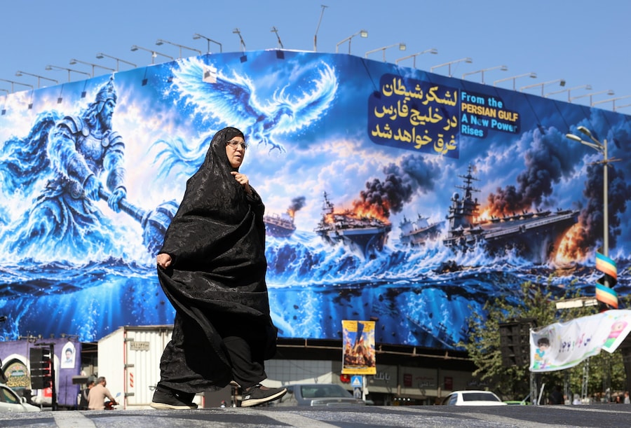 epa13253679 Una donna iraniana velata cammina accanto a un cartellone anti-USA su cui è riportata una frase in persiano che recita: “L’esercito del diavolo sarà annegato nel Golfo Persico”, in piazza Enghelab a Teheran, in Iran, il 21 settembre 2026. (Epa)