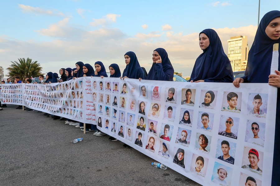 I familiari dei bambini uccisi negli attacchi israeliani dal settembre 2024 portano le loro foto durante una manifestazione in occasione dell’anniversario, all’insegna dello slogan “Settembre, il mese più sanguinoso per i bambini del Libano”, in Piazza dei Martiri a Beirut, in Libano (EPA)