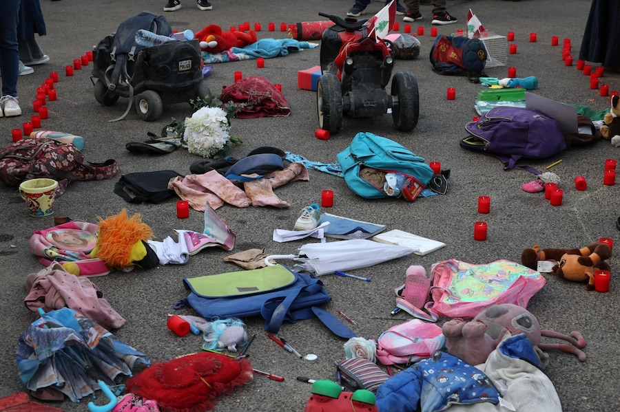Gli effetti personali e i giocattoli dei bambini sono esposti sul pavimento durante una manifestazione per commemorare l’anniversario, all’insegna dello slogan “Settembre, il mese più mortale per i bambini del Libano”, in Piazza dei Martiri a Beirut (Epa)