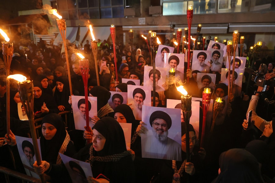 Sostenitori del partito islamista sciita libanese e gruppo paramilitare Hezbollah portano torce e foto di Hassan Nasrallah durante una manifestazione organizzata per commemorare il secondo anniversario della morte del leader di Hezbollah Hassan Nasrallah nel luogo in cui è deceduto a Beirut (Epa)