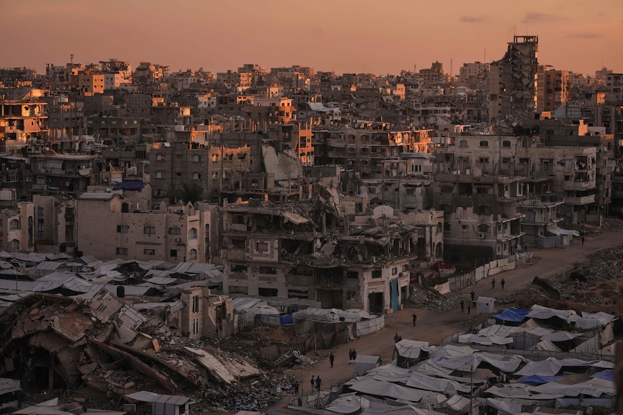 I palestinesi camminano lungo una strada circondata da edifici distrutti dai raid militari israeliani durante la guerra tra Israele e Hamas nella città di Gaza, martedì 6 ottobre 2026. (APN)
