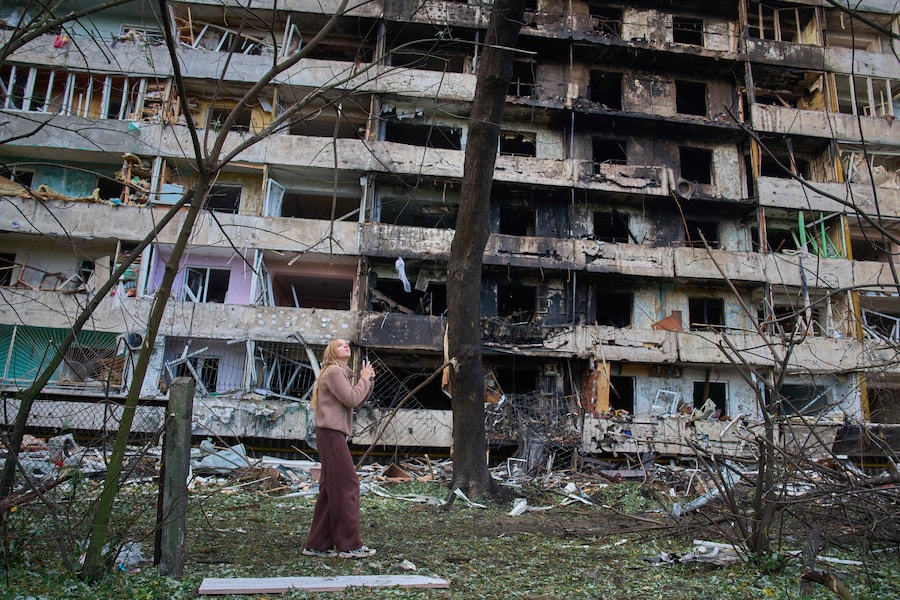 Una giovane donna osserva la propria casa danneggiata dopo l'attacco missilistico sferrato dalla Russia nella notte a Kiev, in Ucraina. (Apn)