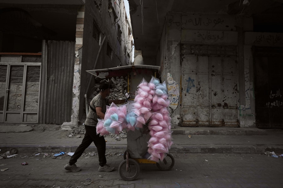 Mercoledì 28 ottobre 2026, un venditore palestinese di zucchero filato spinge il suo carretto per le strade di Gaza City. (Foto AP/Jehad Alshrafi) (APN)