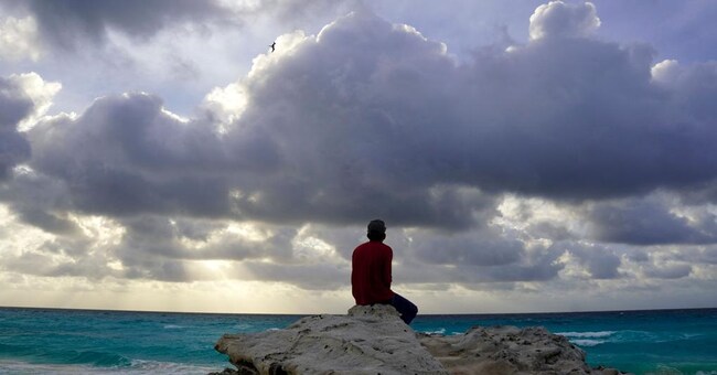 Un turista rimane su una spiaggia chiusa come misura precauzionale a causa del passaggio dell’uragano Milton a Cancun, nello stato di Quintana Roo, in Messico, l’8 ottobre 2024. (Photo by Elizabeth RUIZ / AFP)